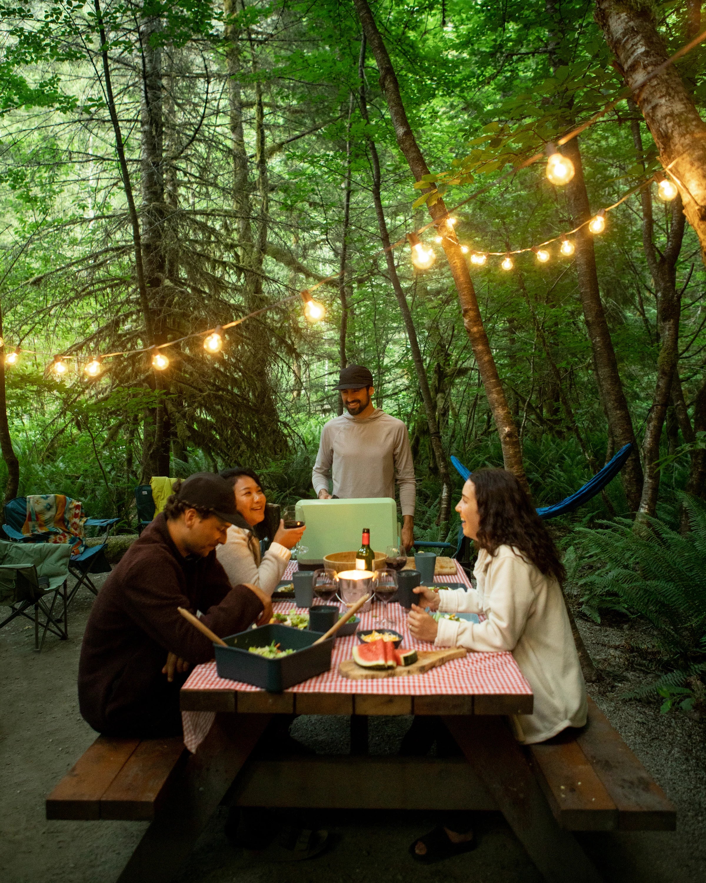 Group of campers having a fancy dinner at the picnic table